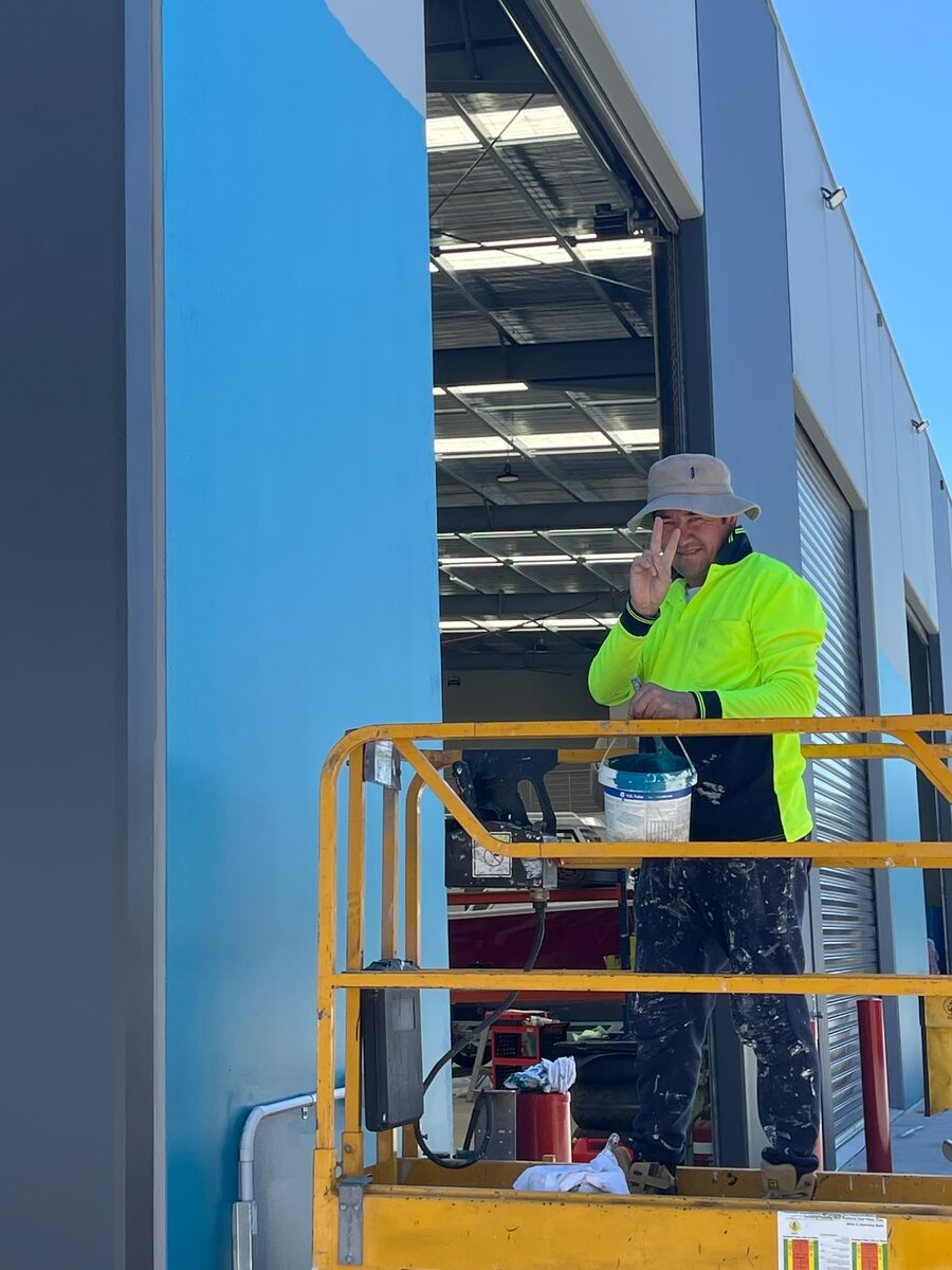 Painter on a scissor lift coating a commercial building interior