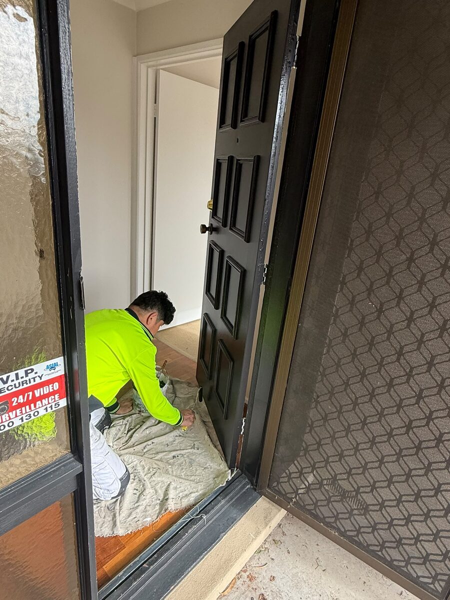 Painter finishing a timber door by hand