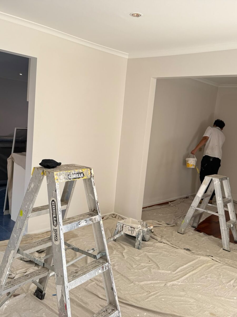 Painter on a ladder repainting an interior room